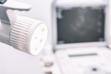 Masa lambası doktorun ofisinde ultrason makinesinin yatay fotoğrafının monitörünün bulanık arka planında parlıyor.