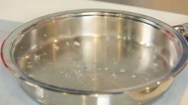 Yakıcı sıcak tava üzerinde su bırakarak