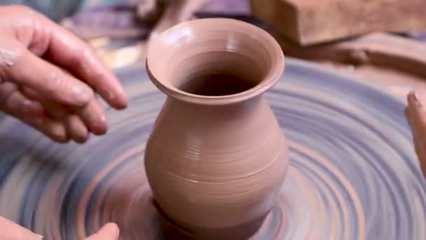Potter at work teaching young student — Stock Video