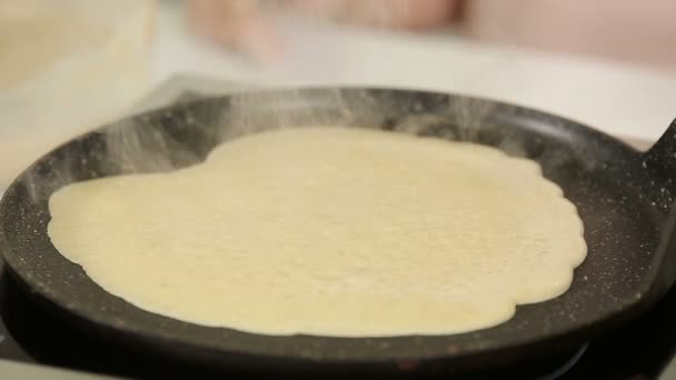 Verser la pâte liquide sur une poêle chaude pendant la friture des crêpes — Video