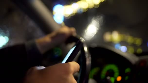 Using smartphone while driving at night in the city — Stock Video