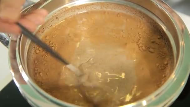 Таяние шоколада с молоком в кастрюле — стоковое видео