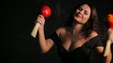 Çekici genç esmer müzisyen kırmızı marakas oynarken