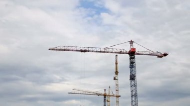 İnşaat alanında bir yağmurlu bir gün Timelapse üzerinde gri bulutlu gökyüzü altında çalıştığı Vinçler