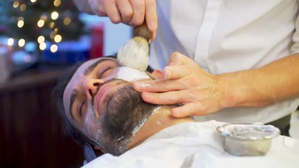 Бородатий чоловік отримує бороду стрижку і голиться — стокове відео