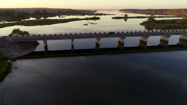 Vista aérea de uma ponte através do rio largo no por do sol — Vídeo de Stock