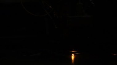 Parlak kıvılcımlarla metal kesen lazer.