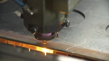 Parlak kıvılcımlarla metal kesen lazer.