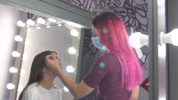 Makijaż artysta noszenie maski w pracy stosując model makijaż — Wideo stockowe