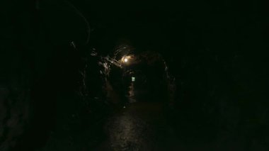 Exploring touristic attraction of a dark cave with an underground tunnel
