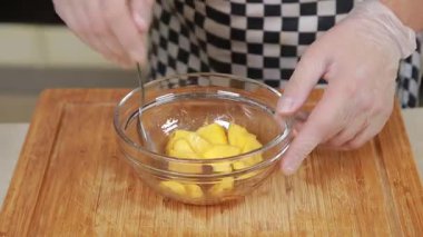 Chef is seasoning fresh pumpkin as ingredient in a glass bowl