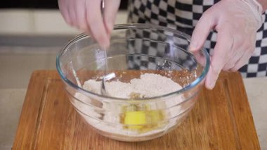 Chef is mixing egg with dry ingredients preparing dough for baked bread baskets