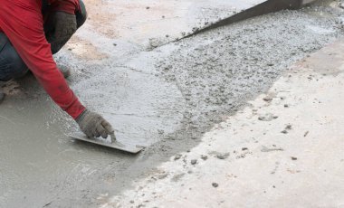 İşçiler beton zemini düzleştiriyor..