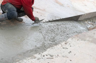 İşçiler beton zemini düzleştiriyor..