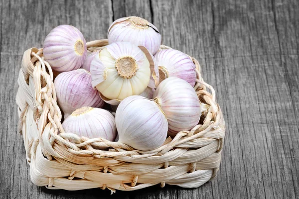 Tumpukan Bawang Putih Dalam Wicker Atas Meja Kayu Abu Abu — Stok Foto