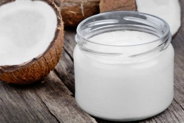 Bir kavanoz ve ahşap masa üzerinde taze Hindistan cevizi Hindistan cevizi yağı