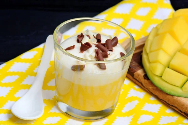 Pudding of mango with whipped cream and chocolate in a glass jar on towel — Stock Photo, Image
