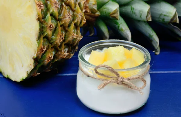 Vaso di vetro con yogurt greco e cubetti di ananas su un tavolo di legno — Foto Stock