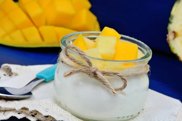 Glass jar with yogurt and pineapple cubes and mango — Stock Photo, Image