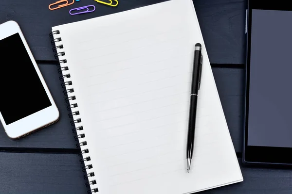 Пустой ноутбук с ручкой, телефоном и цифровым планшетом на столе — стоковое фото