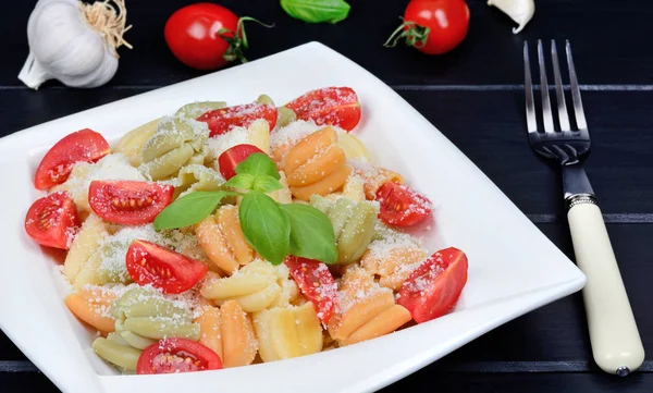 Pasta with cherry tomatoes, parmesan and basil on wooden table — Stock Photo, Image