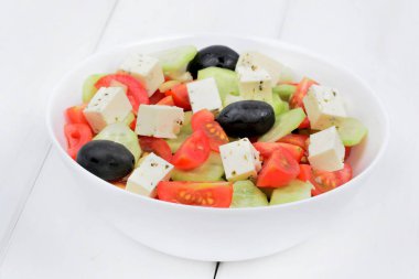 Ahşap masada bir kase peynir ile Sebzeler