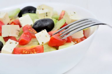 Ahşap masada bir kase peynir ile lezzetli sebze salatası