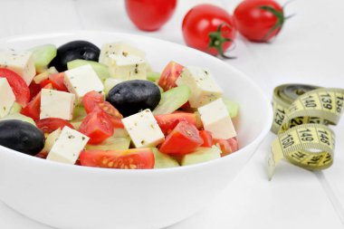 Masada santimetre ile bir kase sebze salatası