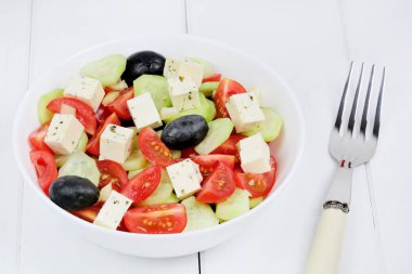 Bir ahşap masada peynir ile Sebze salatası