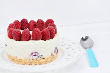 Ahşap bir masada beyaz çikolata ve ahududu ile Mini cheesecake