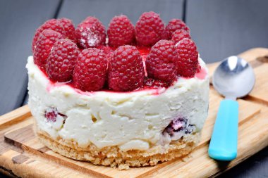 Kesme tahtası üzerinde beyaz çikolata ve ahududu ile Mini cheesecake