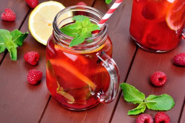 Ahşap bir masada bir kavanoz içinde ahududu limonata