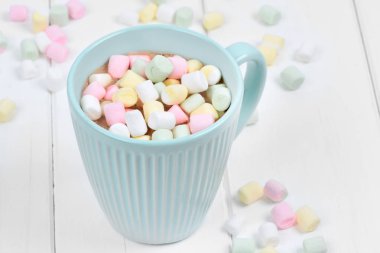 Ahşap bir masada bir fincan renkli marshmallow ile sıcak çikolata