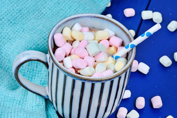 Masada bir fincan mini renkli marshmallow ile sıcak çikolata