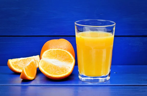 Jus d'orange dans un verre sur une table en bois — Photo