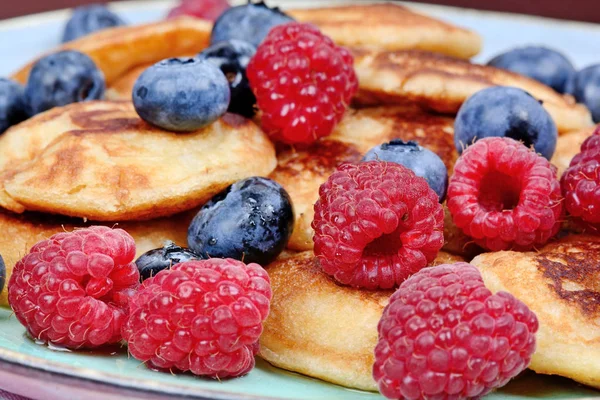 Kleine Pfannkuchen mit Beeren und Agavensirup in einem Teller — Stockfoto