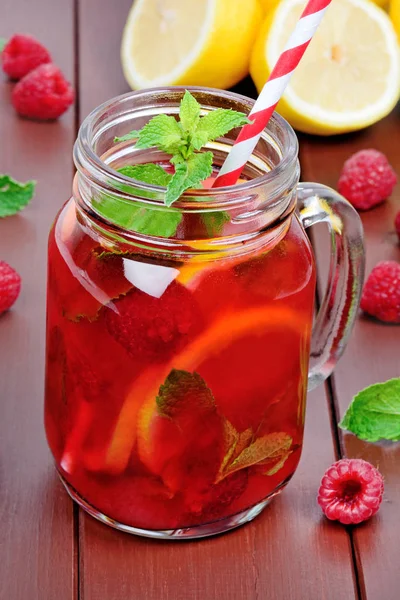 Ahşap bir masa üzerinde bir kavanozda ahududu limonata Taze