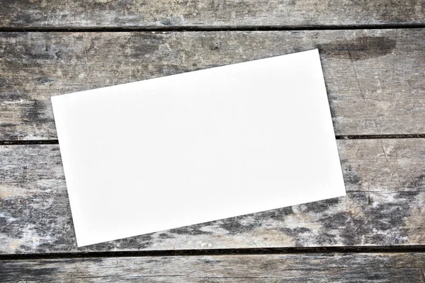Eski ahşap bir masada boş bir kağıt.
