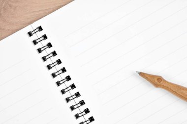 Masanın üzerinde kalem olan boş bir defter
