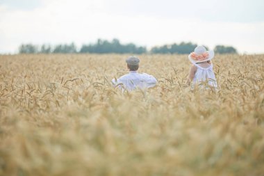 Gündüz sırasında buğday alanında Genç beyaz çocuk ve kadın