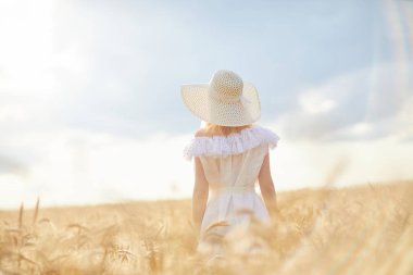 gündüz sırasında buğday alanında şapkalı beyaz kadın
