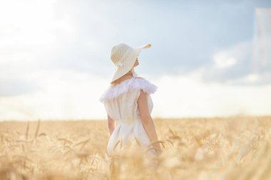 gündüz sırasında buğday alanında şapkalı beyaz kadın