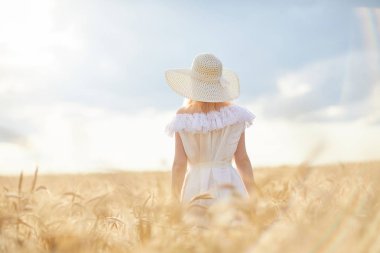 gündüz sırasında buğday alanında şapkalı beyaz kadın