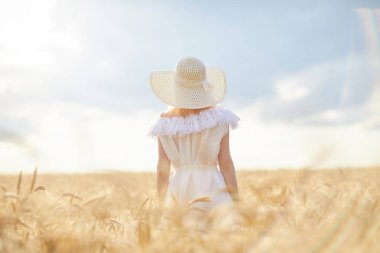 gündüz sırasında buğday alanında şapkalı beyaz kadın