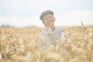 Gündüz sırasında buğday alanında Genç beyaz çocuk