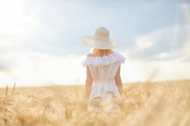 gündüz sırasında buğday alanında şapkalı beyaz kadın