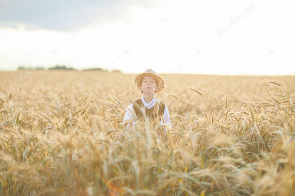 Young caucasian boy on wheat field during daytime