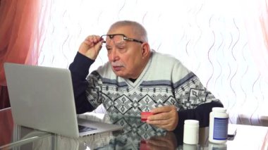 üst düzey adam dizüstü bilgisayar ekranından okur ve kartvizit tutar