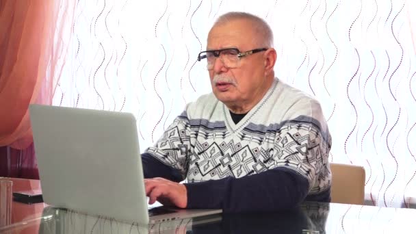 Ηλικιωμένοι τύποι σε φορητό υπολογιστή έχει συνομιλίες στο τηλέφωνο — Αρχείο Βίντεο