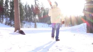 adam parlak güneş ışığına karşı kayak merkezine kayak ile gider